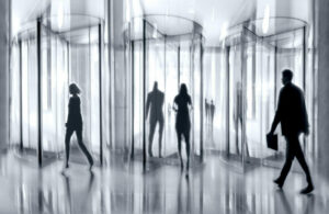 Staff turnover concept. Shadowy figures heading towards revolving doors