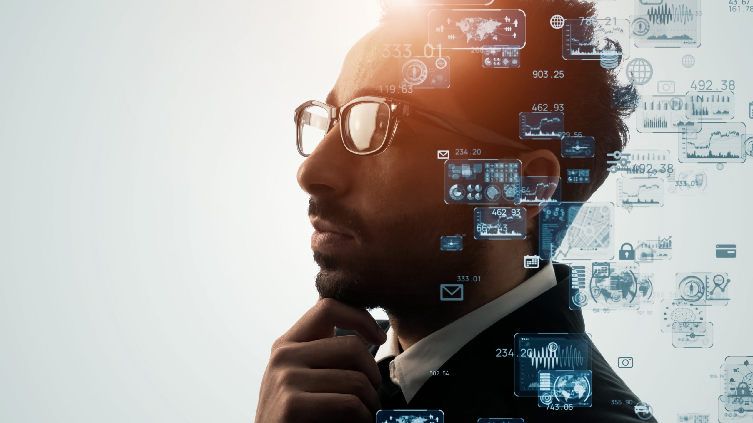 Digital transformation concept. Bespectacled young man pondering with tech icons floating around him